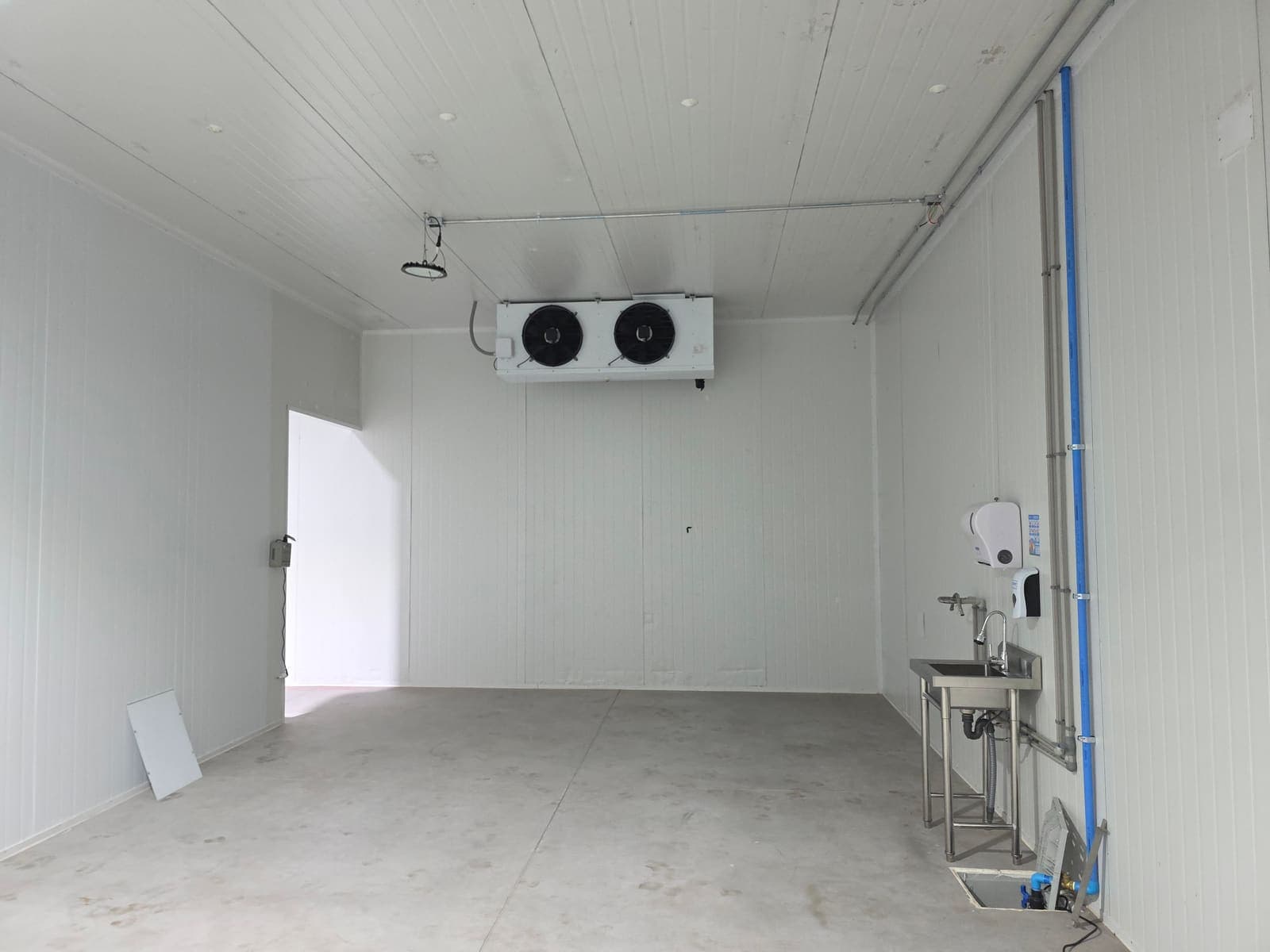 Sala con evaporador de dos ventiladores y lavamanos de acero